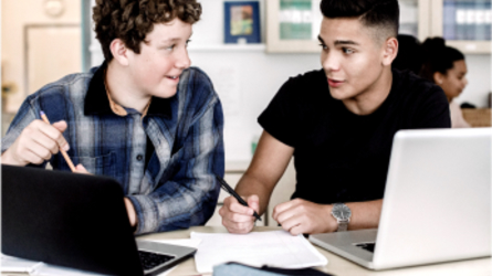 Two young men working on laptops.